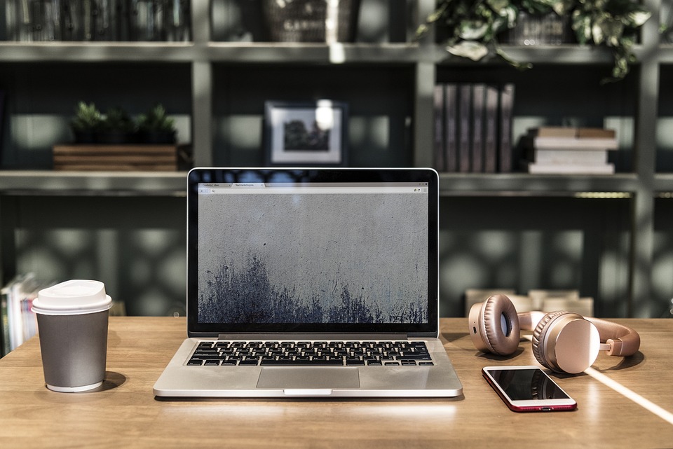 laptop and phone and headphones on desk